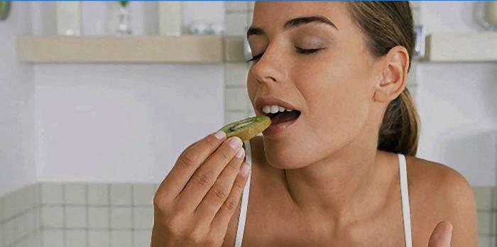 Woman eating a healthy kiwi