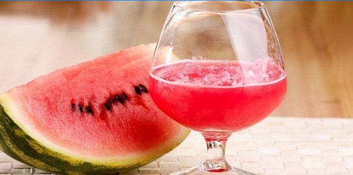 Watermelon tincture on vodka in a glass and a slice of watermelon