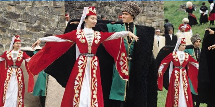 Women and men in Chechen costumes dance