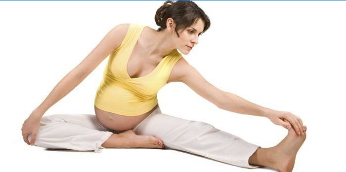 Pregnant girl doing stretching exercise