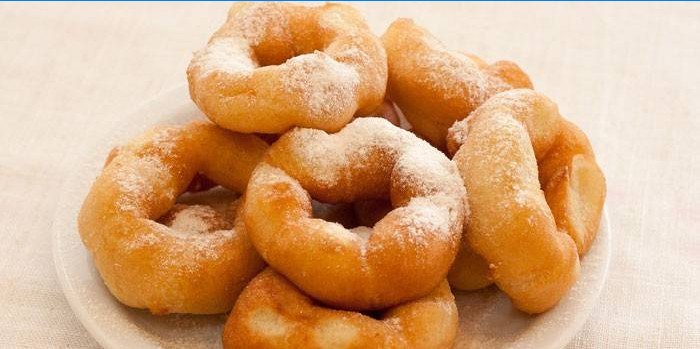 Donuts with a hole sprinkled with powdered sugar
