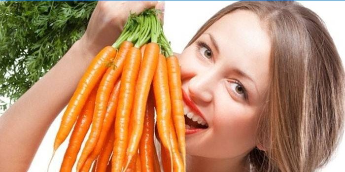 Girl holds a bunch of carrots