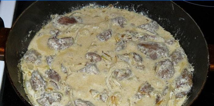 Frying pan with chicken liver in sour cream sauce