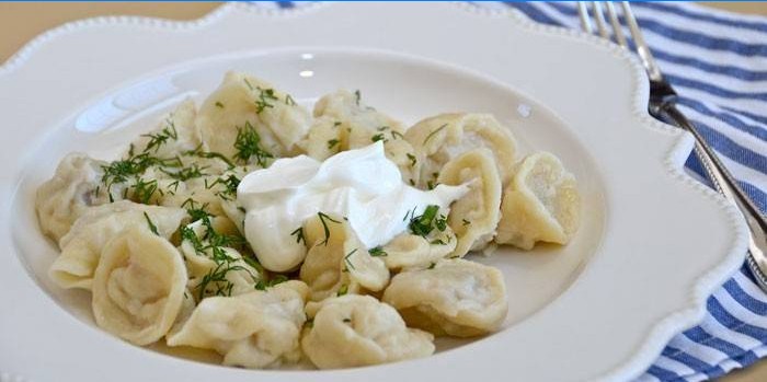 Boiled dumplings with sour cream and herbs