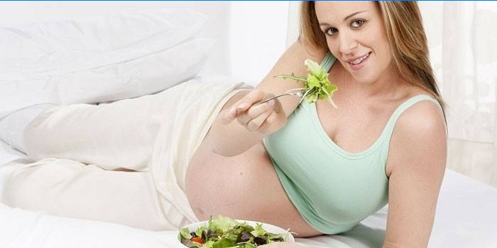 Pregnant girl eats salad