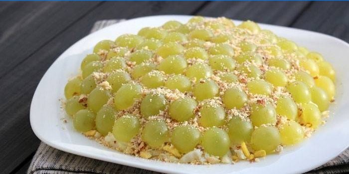 Salad decorated with white grapes and pine nuts