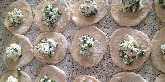Stuffed salted cottage cheese and greens on slices of dough