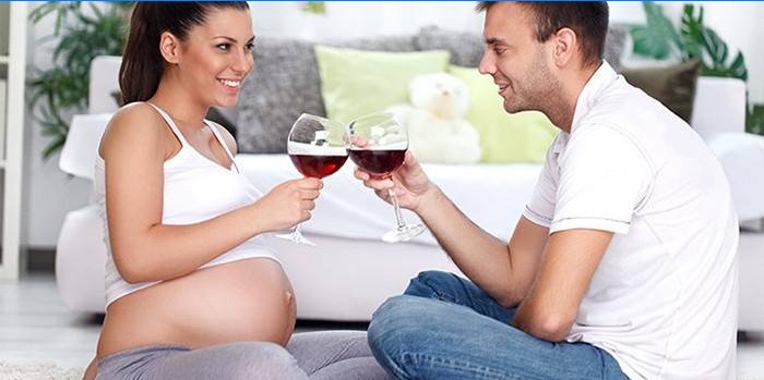 Pregnant woman drinks wine in the company of a man