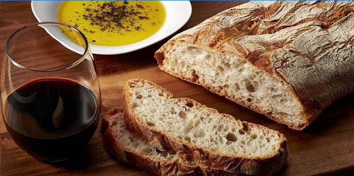 Ciabatta, a glass of wine and olive oil with spices