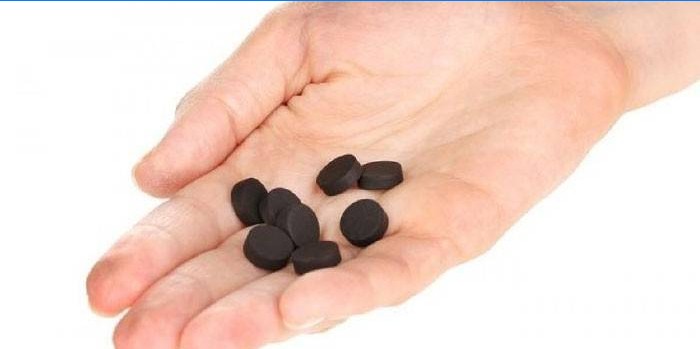 Activated carbon tablets in the palm of your hand