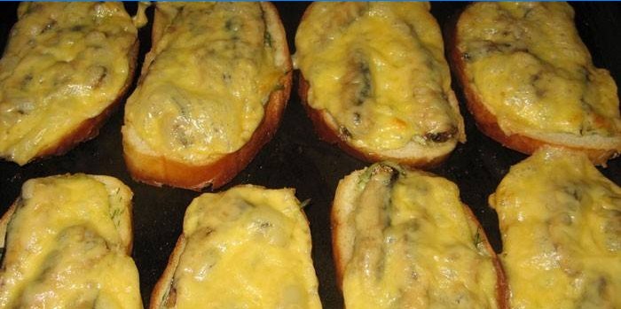 Hot sandwiches with sprats on a baking sheet