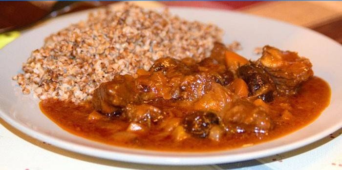 Beef meat in sweet and sour sauce with prunes and buckwheat