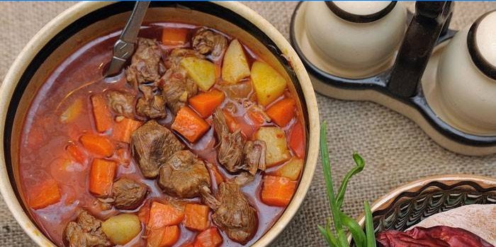 With potatoes, carrots and meat
