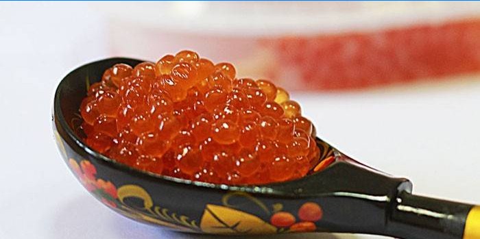 Pink salmon caviar in a wooden spoon