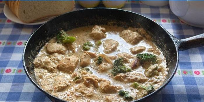 Braised slices of turkey with broccoli in a creamy sauce in a pan