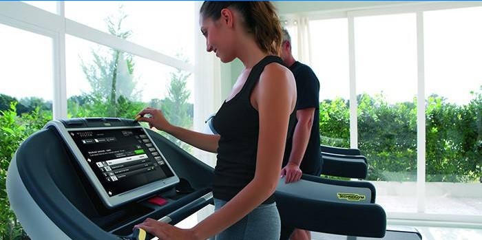 Girl chooses treadmill workout program