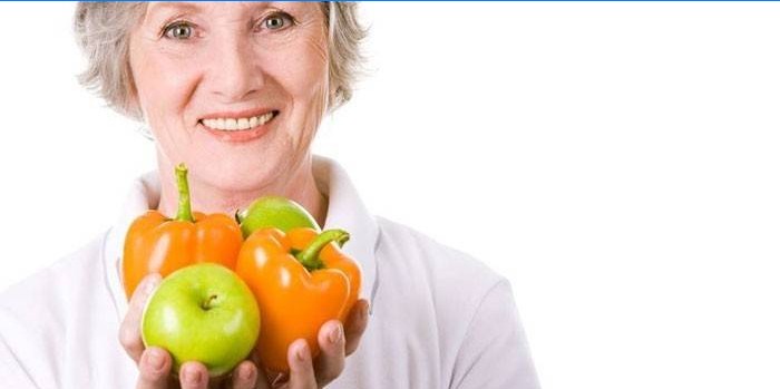 Woman holds apples and peppers