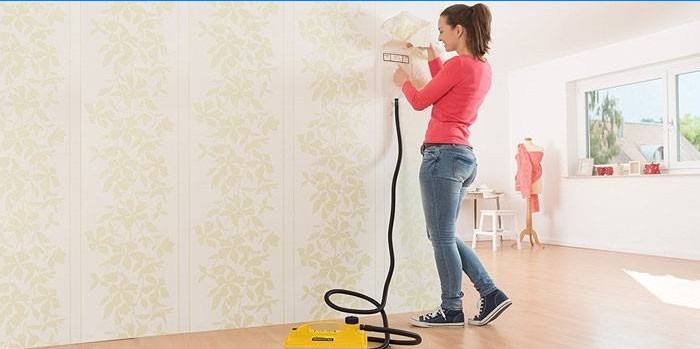 Girl removes wall covering with a steam generator