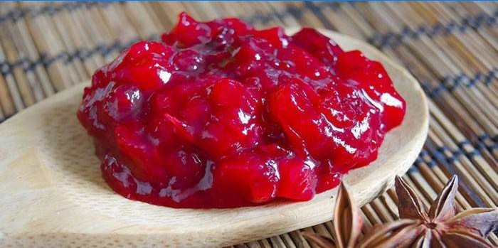 Sauce with oranges and cranberries in a spoon