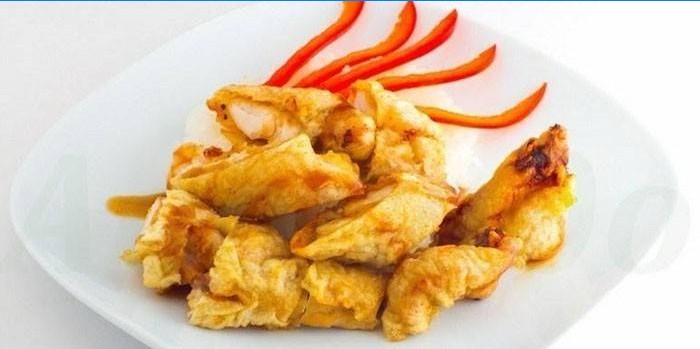 Sliced ​​fried chicken fillet in batter on a plate