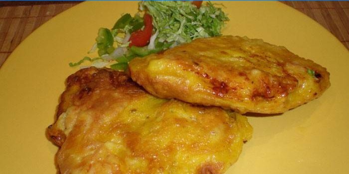 Two fried pieces of chicken breast in batter