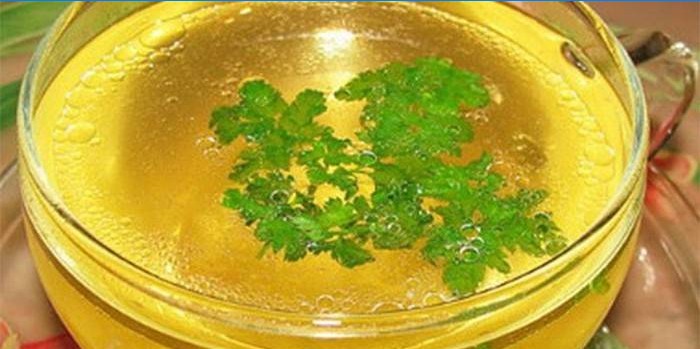 Light chicken broth with parsley in a cup