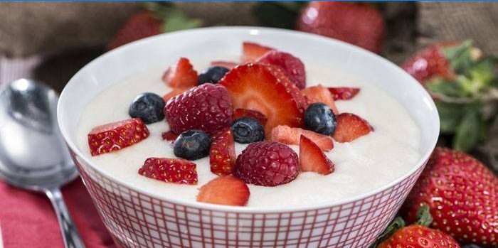Plate of semolina porridge with strawberries, raspberries and blueberries