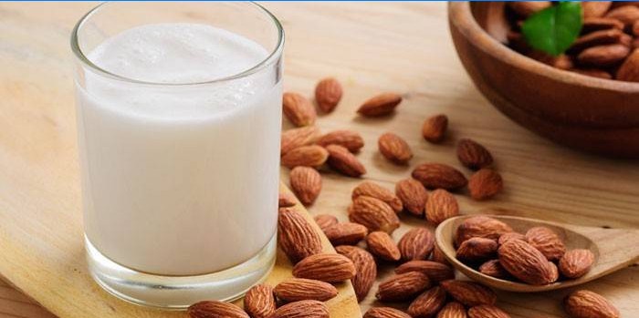 Milk in a glass and almond kernels