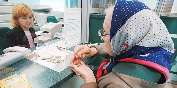 Elderly woman receives a pension at the bank