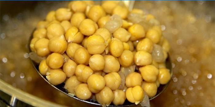 Boiled chickpeas on a slotted spoon