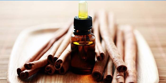 Cinnamon sticks and a bottle of essential oil