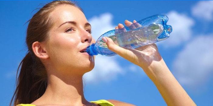 Girl drinks water from a bottle