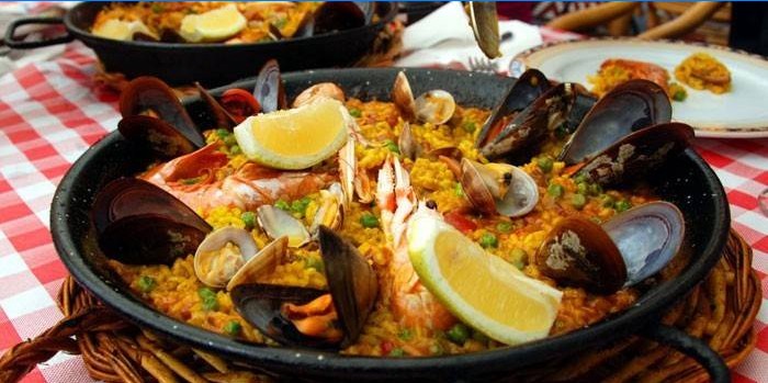 Ready-made paella with seafood and lemon in a pan