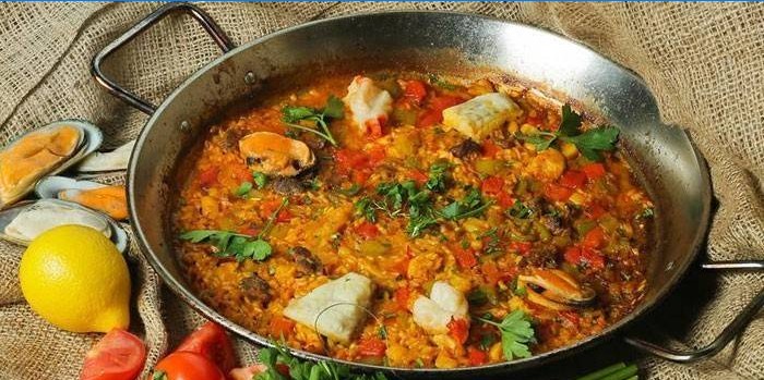 Paella with fish and mushrooms in a pan