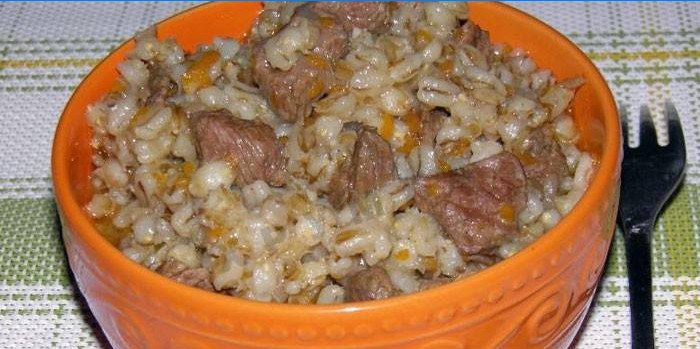 cooked pearl barley porridge with carrots and meat