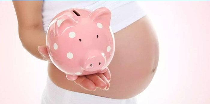 Pregnant girl with a piggy bank