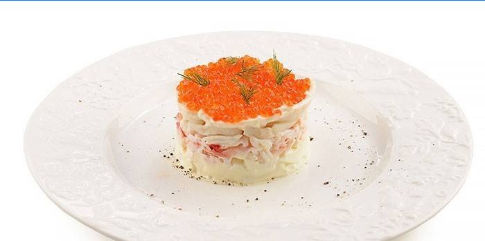 Serving squid salad with red caviar