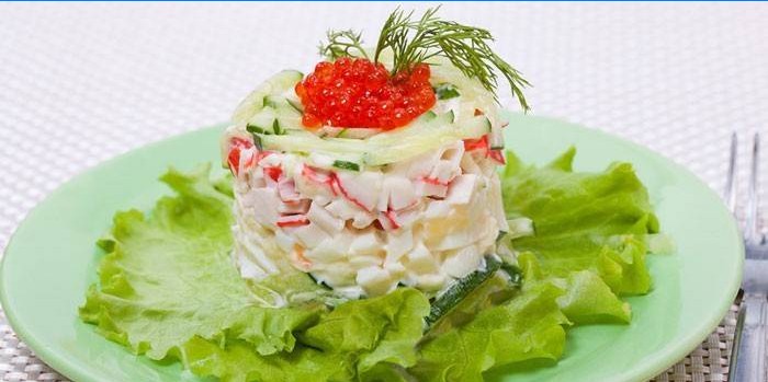 Portion of Tsarskiy salad with crab sticks and red caviar