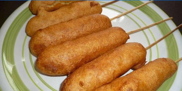 Fried sausages on a stick in the dough