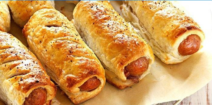 Ready-made sausages in puff pastry on baking paper