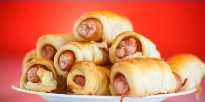 Sausages with cheese in a puff pastry on a plate