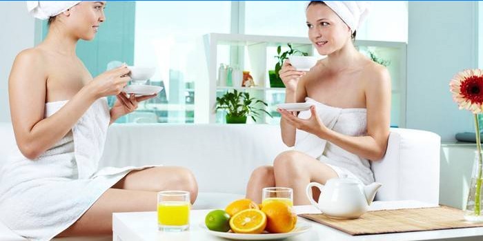 Two girls drink tea and juice at the spa