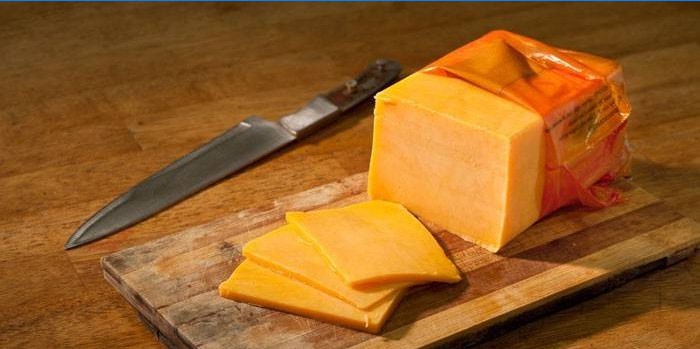 Cheddar Cheese on a Cutting Board