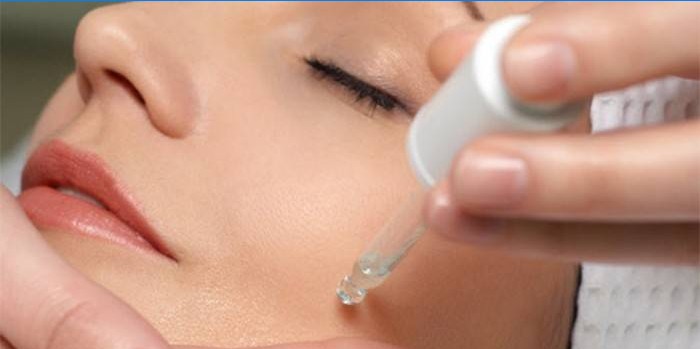 Pipette serum on woman’s face
