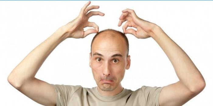 Man holds hands on the hair on his head.