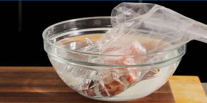 Defrosting meat in a bowl of cold water