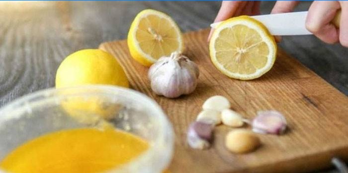 Woman cuts lemon and garlic