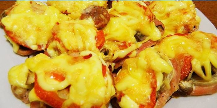 Baked meat with tomatoes under a cheese cap