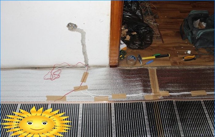 Electric underfloor heating under laminate and linoleum on a wooden floor