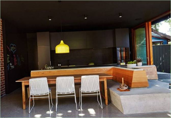 The combination of dark tones of the kitchen with wood furniture and elements